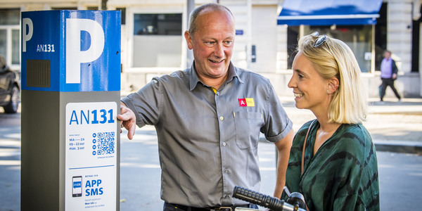 Parkeerwachter geeft uitleg aan bezoeker.